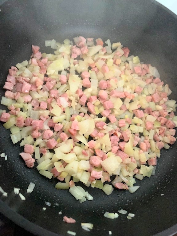 Once the garlic, bacon and onion is cooked, add the cooked pasta and potatoes.