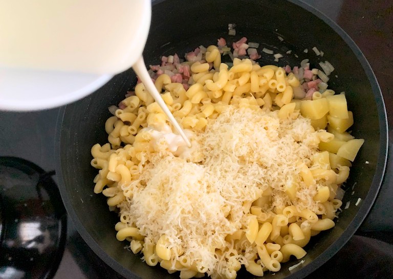 Add the grated cheese, butter and cream to the dish and stir.